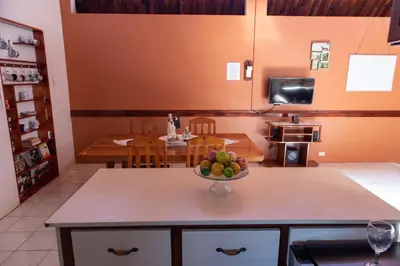 a kitchen with a bowl of fruit on a table at Hostel Bouganvilia Bed and Breakfast in San Ramón