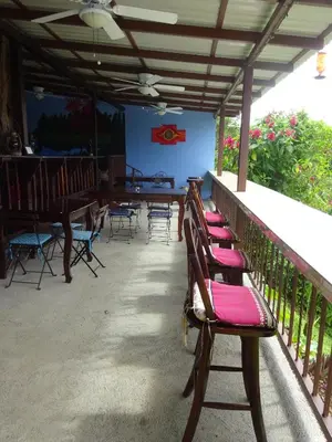 a row of wooden benches sitting on a porch at Toucan Lane in Nuevo Arenal