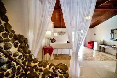 a bedroom with a bed and a white curtain at Toucan Lane in Nuevo Arenal