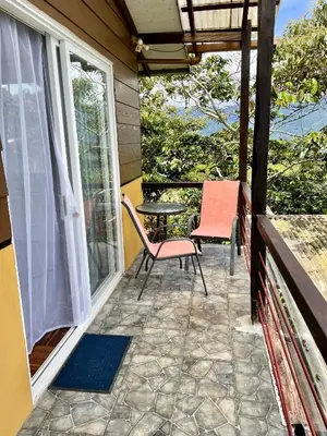 a patio with a table and chairs on a balcony at Rinconcito Verde in Ujarrás