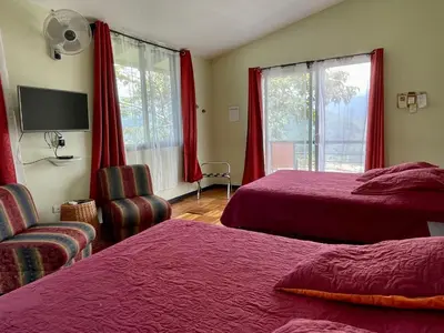 a hotel room with two beds and a chair at Rinconcito Verde in Ujarrás