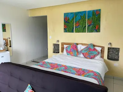 a bedroom with a large bed with colorful pillows at Rinconcito Verde in Ujarrás