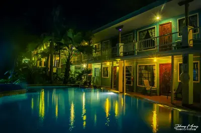 a swimming pool in front of a building at night at Hotel Verde Mar Direct Beach Access in Manuel Antonio