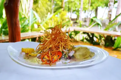 a plate of food with vegetables on a table at Karahe Beach Hotel in Manuel Antonio
