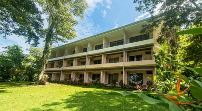 an apartment building with a lawn in front of it at Karahe Beach Hotel in Manuel Antonio