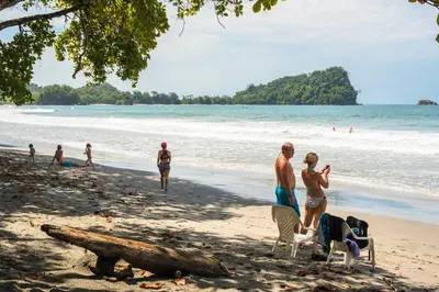 a group of people standing on a beach at Karahe Beach Hotel in Manuel Antonio