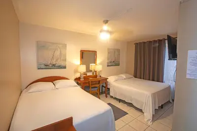 a hotel room with two beds and a desk at Hotel Laura's House in Coco