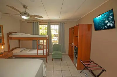 a bedroom with a bunk bed and a tv in it at Hotel Laura's House in Coco