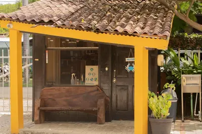 a bench in front of a building with a roof at Hotel Laura's House in Coco
