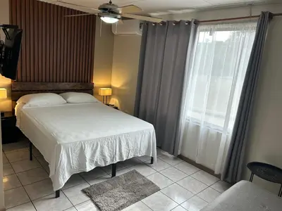 a bedroom with a white bed and a window at Hotel Laura's House in Coco