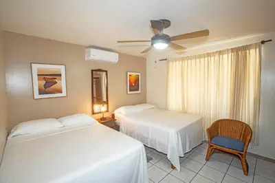 a bedroom with two beds and a ceiling fan at Hotel Laura's House in Coco