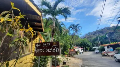 a sign on the side of a building next to a street at Hotel Aurora in Montezuma