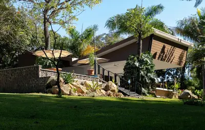 a house with a green lawn in front of it at Guácima Escondida Hotel Boutique in Guácima