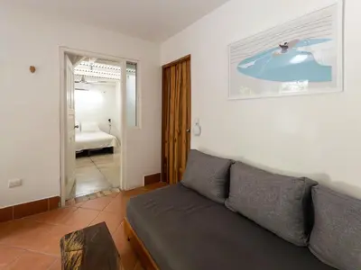 a living room with a couch and a bedroom at Salt Nosara in Nosara