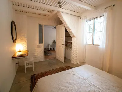 a bedroom with a bed and a room with a window at Salt Nosara in Nosara