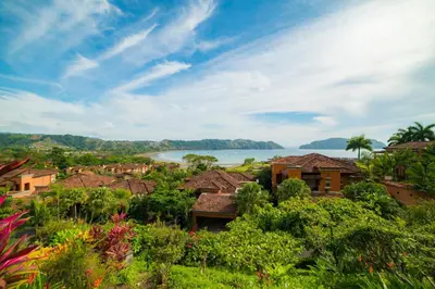 a view of a village with a lake in the background at Marbella 1E 3 bdr Ocean View in Los Suenos in Herradura
