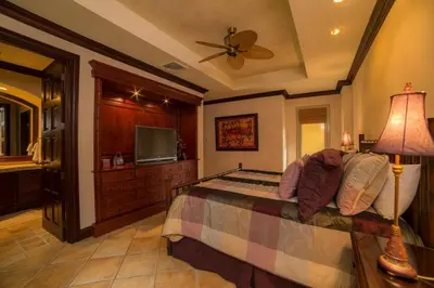a bedroom with a bed and a flat screen tv at Marbella 1E 3 bdr Ocean View in Los Suenos in Herradura