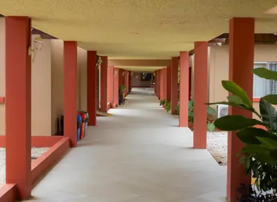 an empty hallway of a school building with red columns at Hotel Las Espuelas, Bar & Restaurant in Liberia