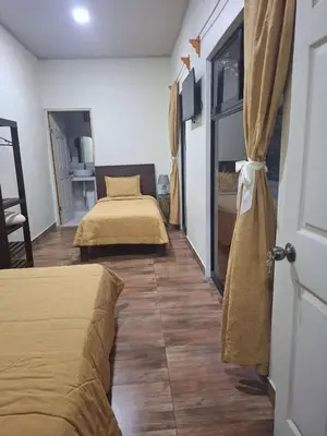 a bedroom with two beds and a room with a table at Hotel San Rafael Ecolodge in San Gerardo
