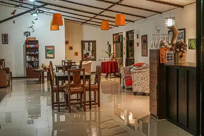 a dining room and living room with a table and chairs at Hotel San Rafael Ecolodge in San Gerardo