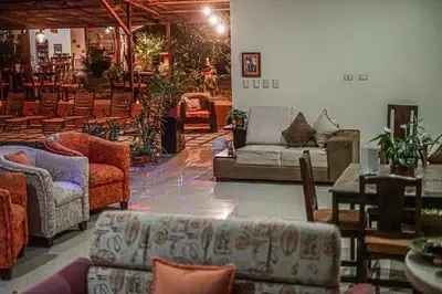 a living room with couches and tables and chairs at Hotel San Rafael Ecolodge in San Gerardo