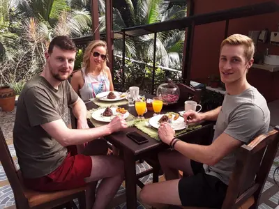 a group of three people sitting at a table eating food at Hotel San Rafael Ecolodge in San Gerardo