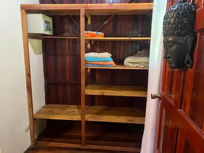 a wooden book shelf with towels in a room at Casas Guaney, full furnished studios! in Manuel Antonio