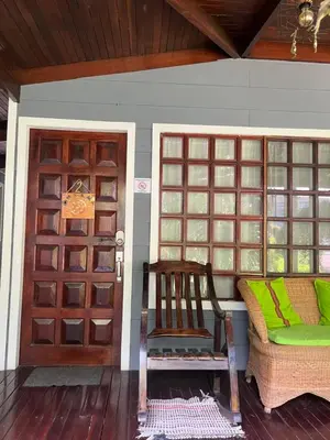 a porch with a wooden door and a chair at Casas Guaney, full furnished studios! in Manuel Antonio