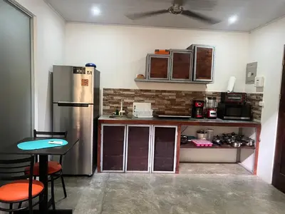 a kitchen with a refrigerator and a table and chairs at Casas Guaney, full furnished studios! in Manuel Antonio