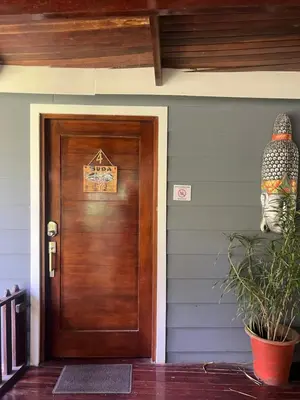 a wooden door in a house with a plant at Casas Guaney, full furnished studios! in Manuel Antonio