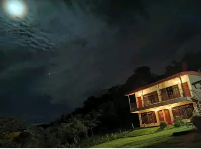 a house at night with the moon in the sky at Monteluna Studios Monteverde in Monteverde Costa Rica