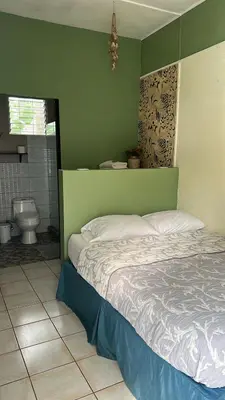 a bedroom with a bed and a bathroom with a toilet at CASA STELLA in Heredia