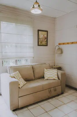 a couch in a living room with a lamp at CASA STELLA in Heredia
