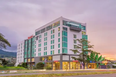 a tall white building with a tree in front of it at Sheraton San Jose Hotel, Costa Rica in San José