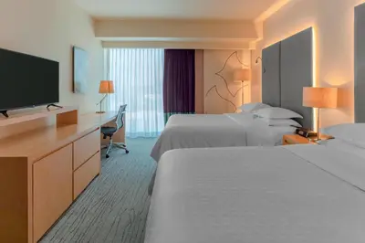 a hotel room with two beds and a flat screen tv at Sheraton San Jose Hotel, Costa Rica in San José