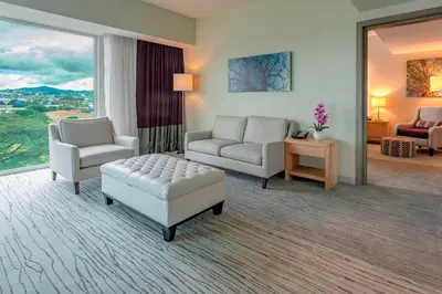 a living room with two chairs and a couch and a table at Sheraton San Jose Hotel, Costa Rica in San José