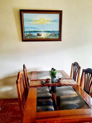 a dining room table with a painting on the wall at Apartamentos Morpho CR 2 in Quepos