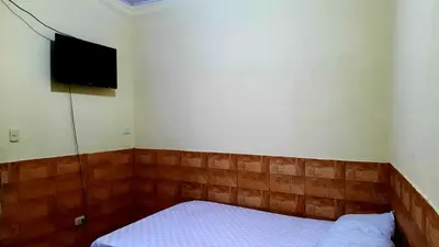 a small bedroom with a bed and a flat screen tv at Apartamentos Morpho CR 2 in Quepos