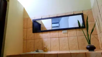 a bathroom with a sink and a mirror on the wall at Apartamentos Morpho CR 2 in Quepos