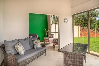 a living room with a couch and a green wall at Casa Sofia, a Gem Close to Orosi Thermal Pools! in Orosí