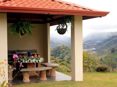 a table and bench under a porch with a view at Casa Sofia, a Gem Close to Orosi Thermal Pools! in Orosí