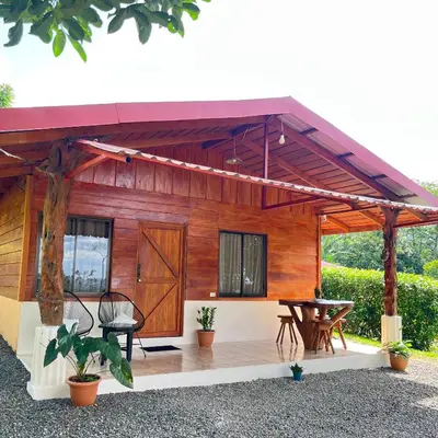 a wooden house with a patio with a table at Cabaña ITZE in Fortuna