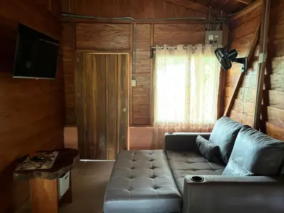 a living room with a couch and a television at Cabaña ITZE in Fortuna