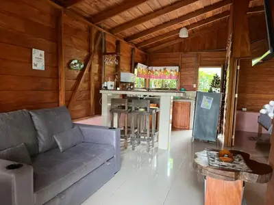 a living room with a couch and a kitchen at Cabaña ITZE in Fortuna