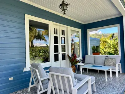a blue house with chairs and a table on a porch at Casa Hacienda La Esperanza in Turrialba