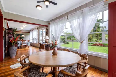 a dining room with a table and chairs and a large window at Casa Hacienda La Esperanza in Turrialba