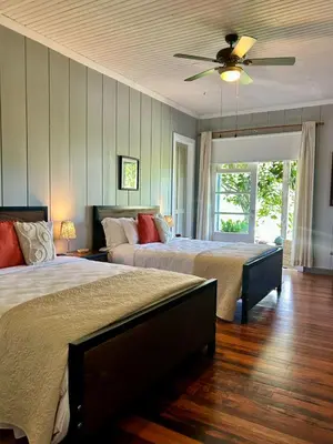 a bedroom with two beds and a ceiling fan at Casa Hacienda La Esperanza in Turrialba