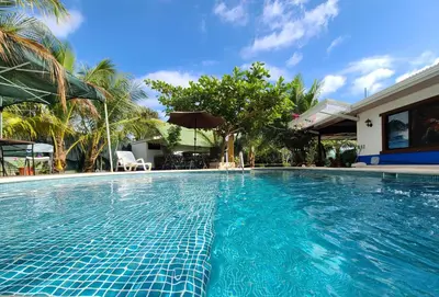 a swimming pool with blue tiles in a house at Jaco Surf Beachbungalow in Jacó