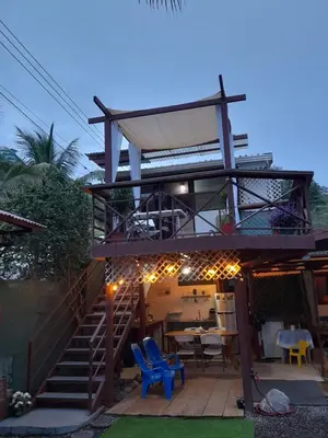a building with a staircase and a table and chairs at Jaco Surf Beachbungalow in Jacó