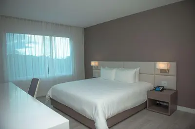 a hotel room with a bed and a window at Hilton Garden Inn Santa Ana, San Jose in San José